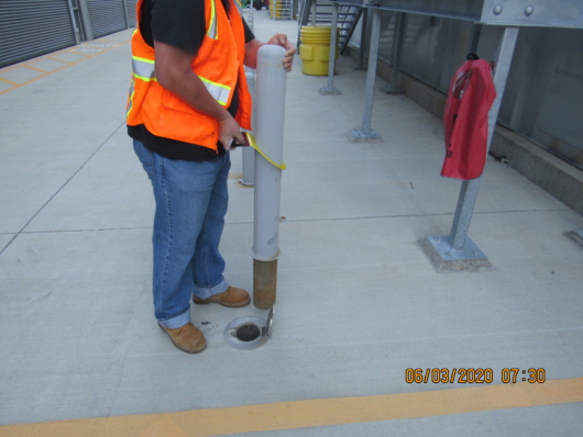 Bollard resting firmly on the ground, after Construction Worker used a Hartman Bollard Lifter to quickly lift a removable pipe bollard from its sleeve.